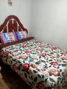 CHIMÚ Lima HOUSE في ليما: سرير مع لحاف الزهور في غرفة النوم