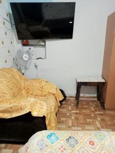 CHIMÚ Lima HOUSE في ليما: غرفة نوم مع سرير وتلفزيون على الحائط