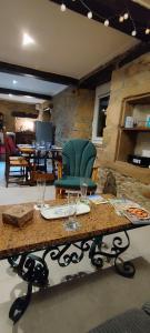 a table with a green chair in a room at Coeur de granit rose, meublé alliant le charme de l'authentique breton et du confort, classé 3 étoiles, à 5mn de 13 plages de la réputée cote de granit rose in Trégastel