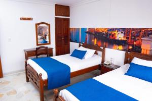 um quarto de hotel com duas camas e vista para uma cidade em Hotel Steven em Buenaventura