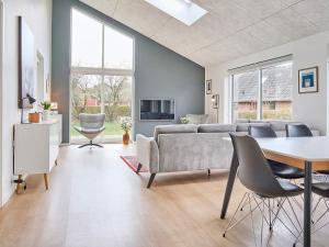 sala de estar con sofá, mesa y sillas en Holiday home Nexø IX en Neksø