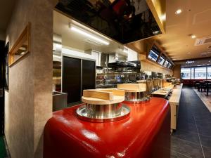 a large kitchen with a red table in the middle at Daiwa Roynet Hotel Gifu in Gifu