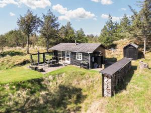 eine kleine Hütte in der Mitte eines Feldes in der Unterkunft 4 person holiday home in Blokhus-By Traum in Blokhus
