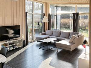 a living room with a couch and a tv at 8 person holiday home in Glesborg in Fjellerup Strand