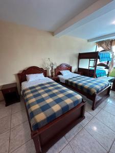1 dormitorio con 2 camas en una habitación en Kanoas Hostal, en Puyo