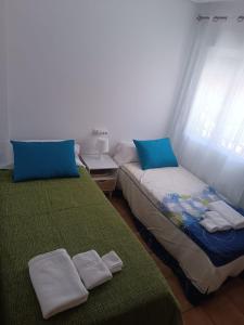 a room with two beds with towels on them at Adosado mediterráneo in Orihuela +23 photos