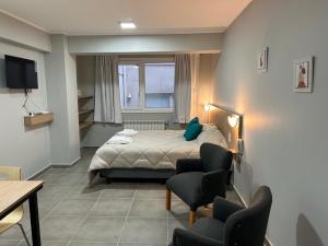 Un dormitorio con una cama y una mesa y sillas. en Monoambiente M670, en San Carlos de Bariloche 1 foto más