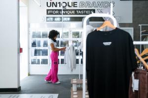 een vrouw in een kledingzaak die naar een shirt kijkt bij Indie Universe Creative Hotel in Medellín