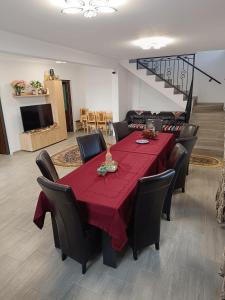 una sala da pranzo con tavolo e sedie rossi di Casuta Din Livada a Moisei