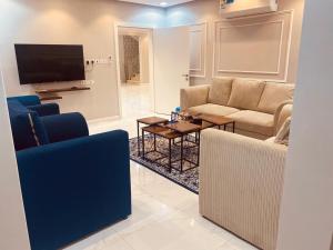 sala de estar con sofás y TV de pantalla plana. en جودة الحياة en Al Kharj