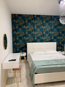 - une chambre avec un lit et un papier peint floral bleu dans l'établissement Casa Ammare, à San Leone