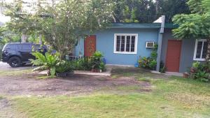 a blue house with a car parked in front of it at Bohol-Simple and Elegant Suite in Tagbilaran City