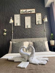 two swans are forming a heart on a bed at Affordable Staycation Studio Rooms Edsa Shaw MRT Greenfield Near Ortigas and Pasig F Residences and Urban deca Shaw in Manila