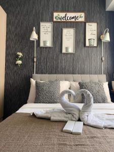 a bedroom with a bed with two swans shaped towels at Affordable Staycation Studio Rooms Edsa Shaw MRT Greenfield Near Ortigas and Pasig F Residences and Urban deca Shaw in Manila