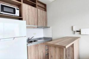 eine Küche mit einem weißen Kühlschrank und einer Mikrowelle in der Unterkunft Rooftop Sunlight Movistar Arena in Buenos Aires + 12 Fotos