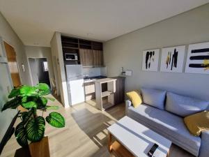 ein Wohnzimmer mit einer blauen Couch und einer Küche in der Unterkunft Rooftop Sunlight Movistar Arena in Buenos Aires