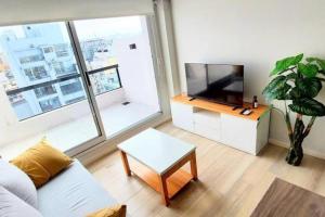 ein Wohnzimmer mit Sofa und Fernseher in der Unterkunft Rooftop Sunlight Movistar Arena in Buenos Aires