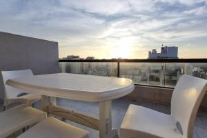 ein weißer Tisch und Stühle auf einem Balkon mit Aussicht in der Unterkunft Rooftop Sunlight Movistar Arena in Buenos Aires