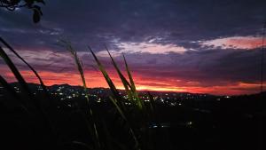 a sunset with a view of a city at Finca el oserno in Don Rubén