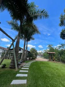 Una pasarela con palmeras en un parque en Familien Haus Pousada en Pomerode