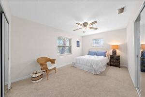 a bedroom with a bed and a ceiling fan at Coastal Chic Home, Walk to Beach in Cocoa Beach