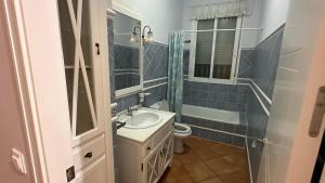 a bathroom with a sink and a toilet and a mirror at Chalet Californiano con Piscina in Morón de la Frontera +17 photos