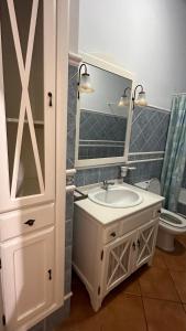 a bathroom with a sink and a mirror and a toilet at Chalet Californiano con Piscina in Morón de la Frontera