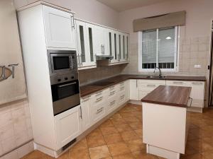 a kitchen with white cabinets and a stove top oven at Chalet Californiano con Piscina in Morón de la Frontera