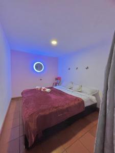 a bedroom with a large bed with purple walls at Prisma Hostel in Bogotá