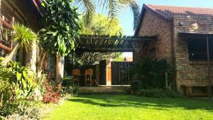 a house with a patio with a grass yard at UrbanEscape in Centurion