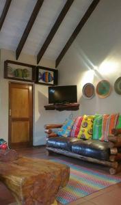 a living room with a leather couch with colorful pillows at UrbanEscape in Centurion