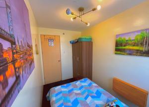 ein Schlafzimmer mit einem Bett und einem Wandgemälde in der Unterkunft Pandora’s Nest in Manila