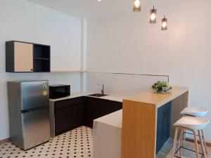a kitchen with a sink and a refrigerator and a counter at Tommy Resort2 in Haad Rin