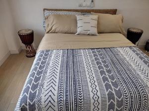 a bed with a blue and white comforter on it at Ivy Residence 4br 6ba with terrasse in Porto-Novo