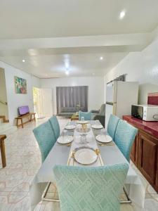 uma sala de jantar com uma mesa e cadeiras azuis em White House Villa em Dumaguete