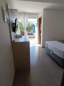 um quarto com uma cama e uma secretária com uma televisão em Residencial Mar Azul-suíte 12 em Pontal do Paraná