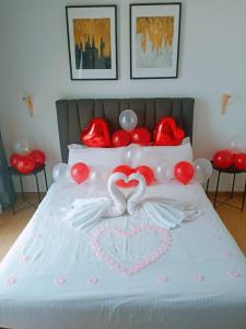 a bed with red and white balloons and a heart on it at Kuantan City 188 in Kuantan +2 photos