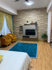 a living room with a bed and a large blue rug at Kuantan City 188 in Kuantan