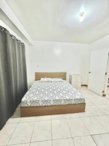 sypialnia z łóżkiem w białym pokoju w obiekcie White House Villa w mieście Dumaguete