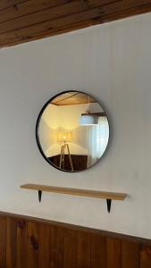 een ronde spiegel aan een muur met een tafel bij Departamento en el corazón de Los Corralitos in Guaymallen