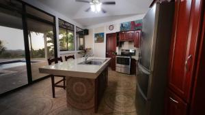 a kitchen with a sink and a refrigerator at Casa pacific vista in Ojochal