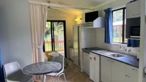 una pequeña cocina con mesa, mesa y sillas en Daintree Beach Resort, en Wonga