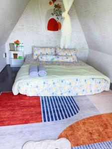 Una cama con almohadas y una alfombra en una habitación en SZ Samui Glamping en Ban Sa Ket