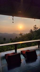 a balcony with pillows and a view of the sunset at SZ Samui Glamping in Ban Sa Ket