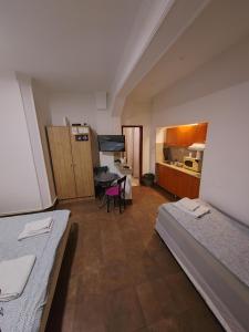 MAGENTA Apartments في بلغراد: غرفة بسريرين ومطبخ مع طاولة