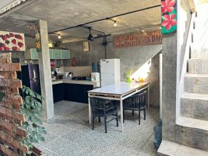La cuisine est équipée d'une table, de chaises et d'un réfrigérateur. dans l'établissement Guest House Home 46 Bali, à Canggu