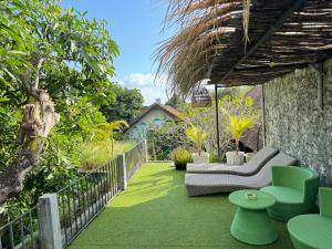 d'une terrasse avec un canapé et des chaises sur gazon. dans l'établissement Guest House Home 46 Bali, à Canggu