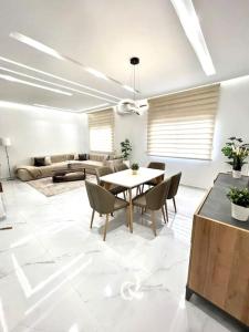 a white living room with a table and chairs at SIAM’S House in El Harhoura