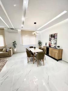 a white living room with a table and chairs at SIAM’S House in El Harhoura