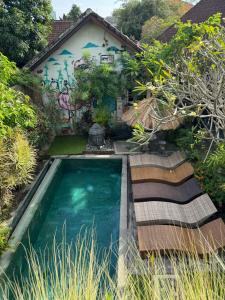 une piscine en face d'une maison avec graffiti dans l'établissement Guest House Home 46 Bali, à Canggu